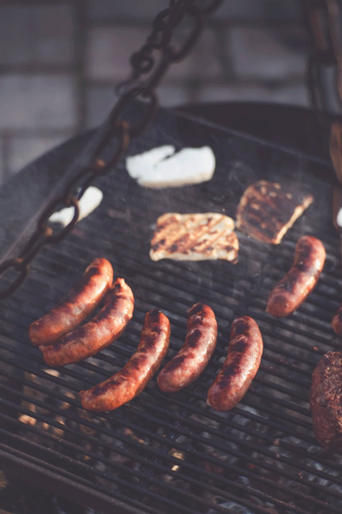 close up of hot dogs on a grill
